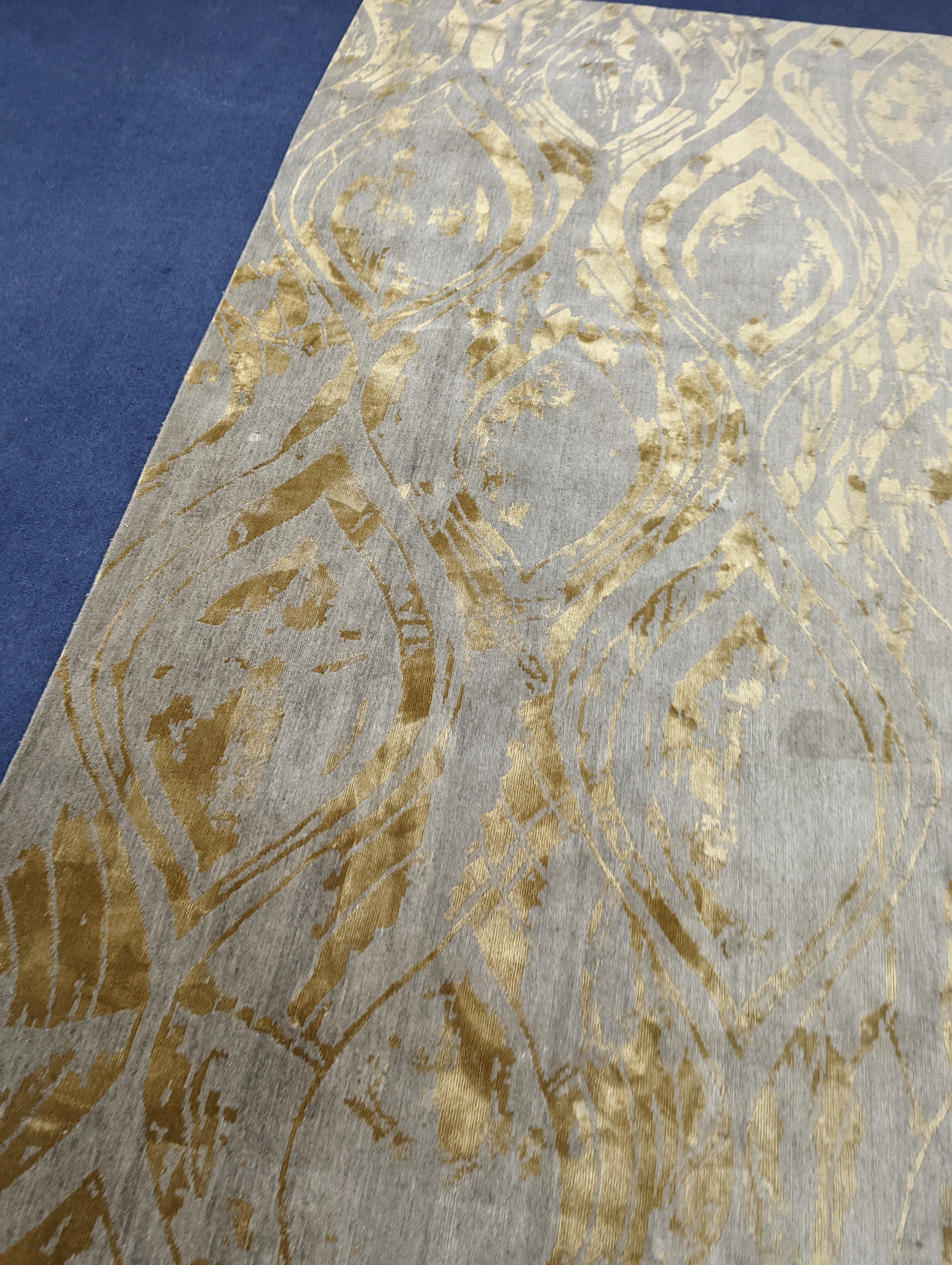 A contemporary 'Son' Nepalese wool and silk stone grey and gold carpet, 490 x 270cm